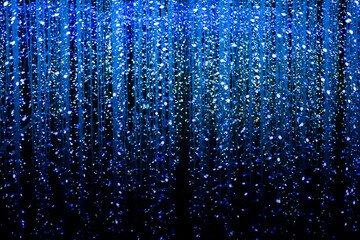 Celebration lights at Christmas New Year festival. Crowd of hanging blue light bulbs blue bokeh background. blue light bulb tunnel. 