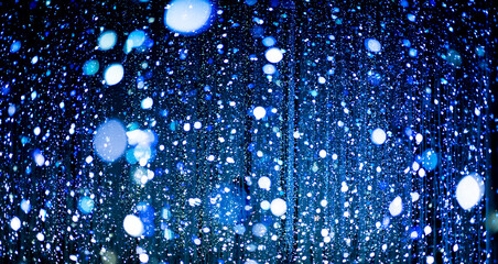 Celebration lights at Christmas New Year festival. Crowd of hanging blue light bulbs blue bokeh background. blue light bulb tunnel. 