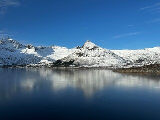 Fototapeta na wymiar Snowy mountains mirrored in a lake