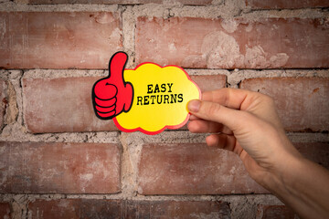 Easy Returns. Sticky note with text on a red brick background