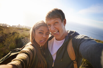 Funny, face and hiking couple with selfie in nature for bonding, fun or goofy memory at sunset....