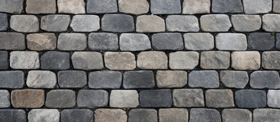 Obraz premium A closeup view of a brick wall showcasing different colored bricks with grass and stone wall in the background. The property features unique brickwork and a durable bedrock foundation