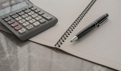 open notebook , pen and calculator on the desk 