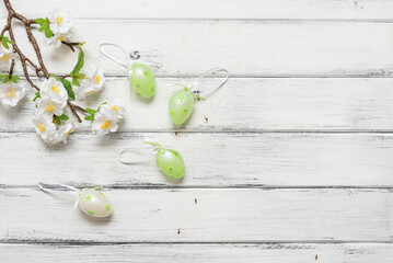 Easter eggs and decorative blossom cherry branch on a white wooden background. Top view, flat lay. - 757105463