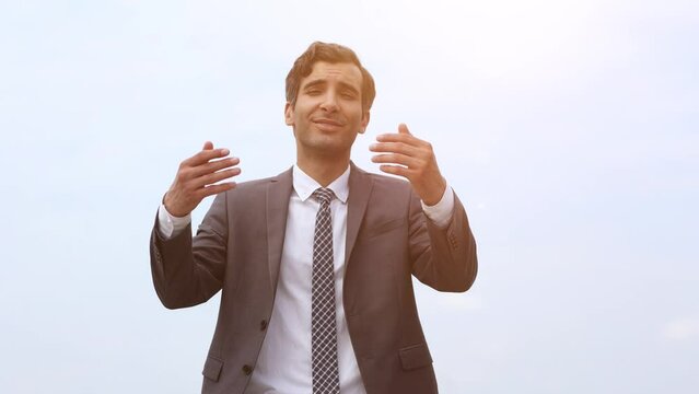Modern businessman smiles and stretches his hand to the camera wishing to greet