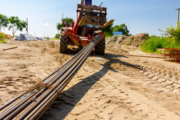 Forklift lifts the rebar bundle from ground on building site