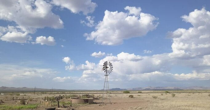 Drone &mdash; slowly moving across the landscape with windmill and massive skies, Texas
