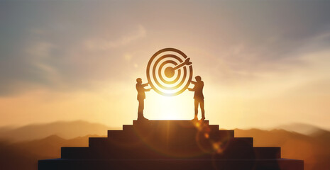 Silhouette of two businessmen holding a target board on highest end of stairs. concept of aim, ...