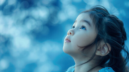 Cute Asian Girl Looking at the Sky - Calm Blue Bokeh Background - Wonderful Child Stock Image