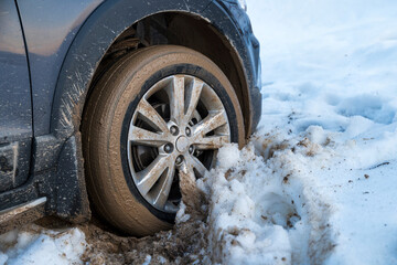 Snowy wheel stuck in mud, a winter driving challenge