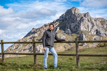 Naklejka premium A middle aged man in a farm with the mountains at the background.
