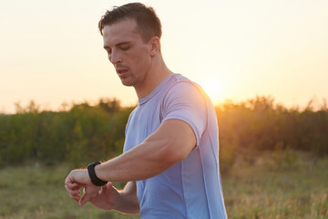 Sunny Run: Athlete Checks Smartwatch While Running in the Sun.