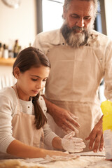 Girl, child and grandpa with dough in kitchen for cooking, baking and teaching with support and helping. Family, senior man and grandchild with flour for preparation in home with bonding and learning