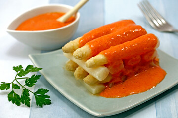 White asparagus with red pepper sauce.