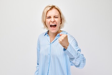 Angry woman yelling with clenched fists on white background expressing frustration or strong emotion