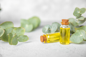 Eucalyptus essential oil in a glass bottle with green eucalyptus leaves on a textured wooden background. Aromatherapy concept. Spa. Natural organic ingredients for cosmetics and body care.Copy space
