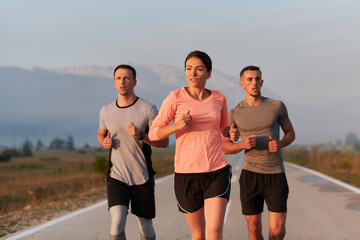 A group of friends, athletes, and joggers embrace the early morning hours as they run through the misty dawn, energized by the rising sun and surrounded by the tranquil beauty of nature
