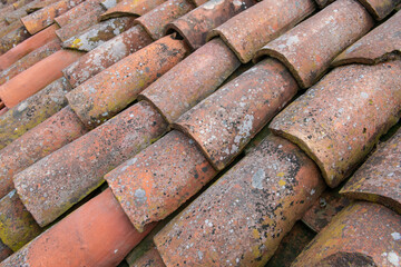 tiled roof supported on a double pitch roof, the old tiles tend to slip over time, because they are not fixed. ancient method of covering. bad weather damage to roofs.