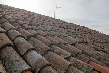 tiled roof supported on a double pitch roof, the old tiles tend to slip over time, because they are...