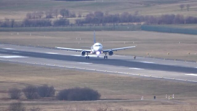 airplane landing at generic airport on runway unmarked white with touchdown and smoke crosswind