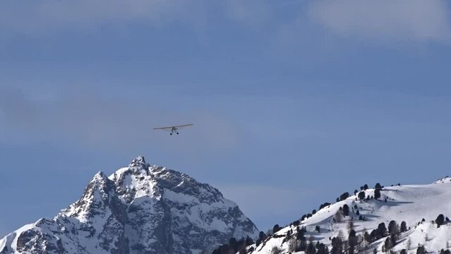 bush airplane flying far away tail view with scenic mountain background winter snow covered ice cold remote location small aircraft