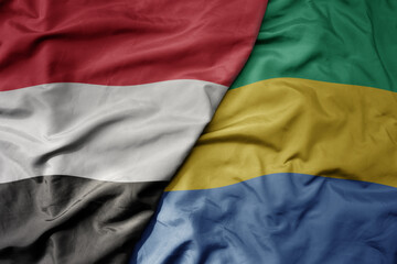 big waving national colorful flag of gabon and national flag of yemen .