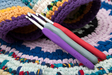 Colored rugs in rustic style and crochet hooks