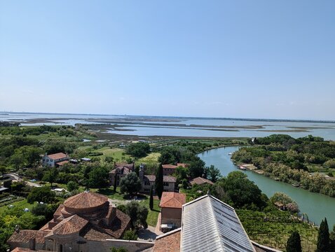 An aerial view of the Torcello island, a part of the Venice lagoon. Looking over the lagoon and the buildings such as the archaeological museums, shops, and the Locanda Cipriani. 