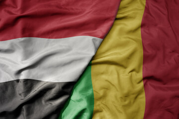 big waving national colorful flag of mali and national flag of yemen .