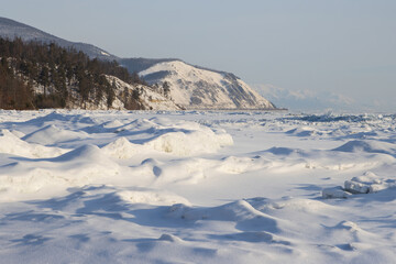 Lake Baikal. Snow-covered ice. Northern coast of Lake Baikal in the vicinity of Severobaikalsk. Republic of Buryatia, Russia. Beautiful winter landscape. Cold weather. Nature of Siberia.