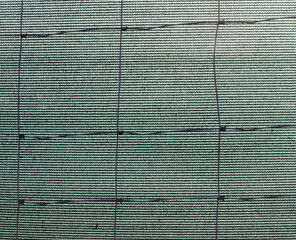 Metal wire fence and synthetic fabric.