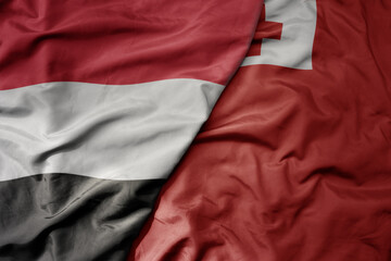 big waving national colorful flag of Tonga and national flag of yemen .
