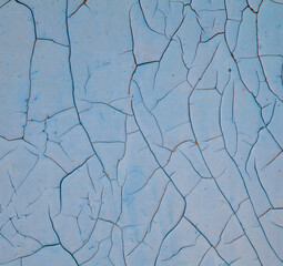 Cracked blue paint on the wooden surface.