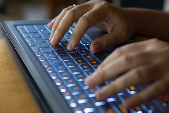 Close up image of hands typing on laptop computer keyboard and surfing the internet at home. Freelancer copywriter working project, typing text, edit something. Remote job concept