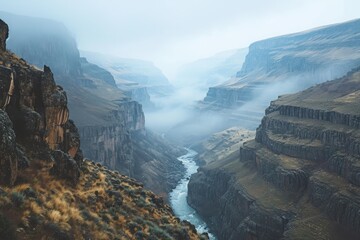 A stunning and majestic view of a river flowing through a breathtaking canyon, enveloped by towering mountains, A deep river canyon with steep cliffs and foggy mornings, AI Generated
