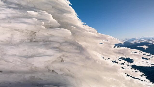 sunset and sunrise on the Montenegrin ridge in the Carpathians, a colorful picturesque spectacle, golden and pink light on the ice, patterned by the wind