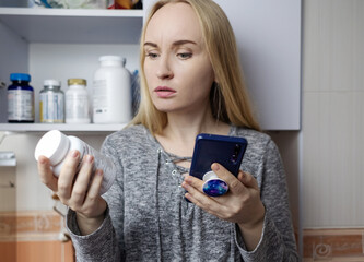 Girl studies dietary supplements. Reading the instructions on a bottle of vitamin complex....