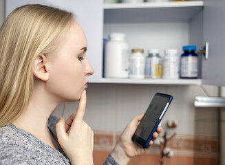 Girl studies dietary supplements. Reading the instructions on a bottle of vitamin complex....