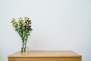 Woman hand arrange Colorful flowers bouquet in mason jar on table background. Happy day with fresh...