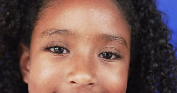 Close-up of a biracial girl with curly hair and a subtle smile