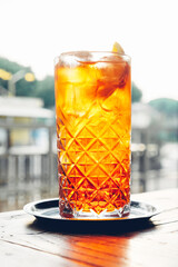 Glass of refreshing Aperol Spritz, popular Italian cocktail and summer aperitif drink prepared with...