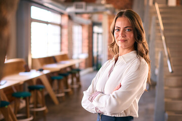 Portrait Of Young Businesswoman With Serious Expression Working In Modern Open Plan Office 