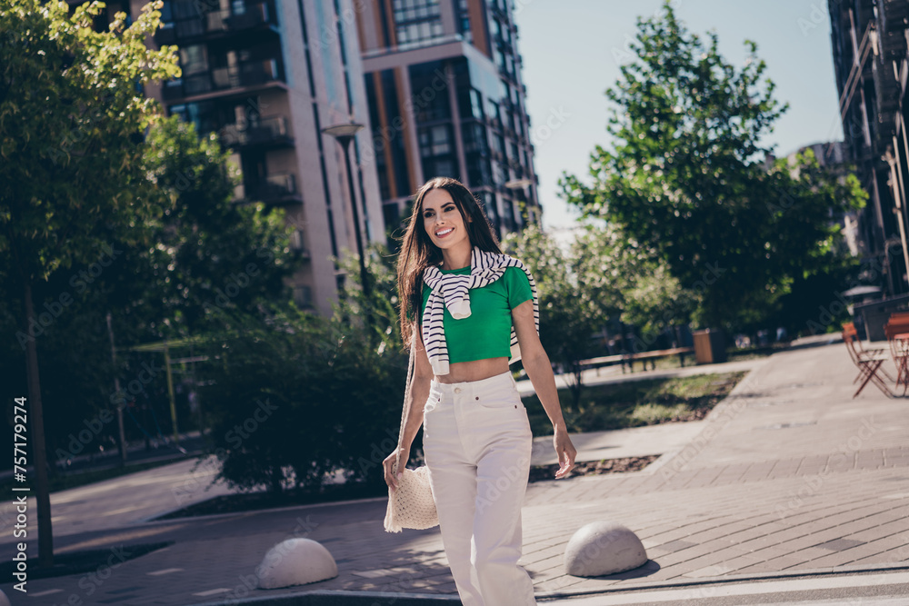 Sticker Photo of positive shiny young lady brunette hair model wear trendy casual outfit enjoying summer vibes walking streets outdoors city