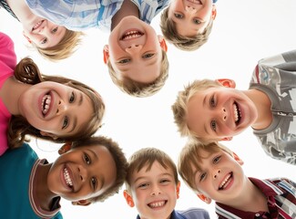 photo of happy multiethnic children huddled together. Group of cute happy kids huddling, looking down at camera and smiling