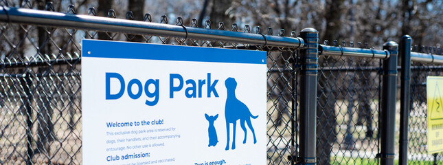 Panorama dog park sign with rules policies on galvanized vinyl-coated chain link fences, steel posts panels at rest area public picnic location along highway in Oklahoma, security fencing gate - Powered by Adobe