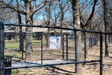 Public rest area dog park with pavilion, galvanized vinyl-coated chain link fences, steel posts and panels, woods bare trees public picnic location along highway in Oklahoma, security fencing - Powered by Adobe