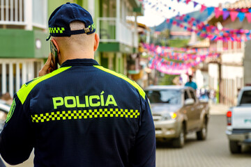 Colombian police officer seen from behind while talking on the phone