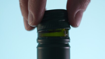 Fingers twist a cap onto a bottle. Close-up, shallow dof.