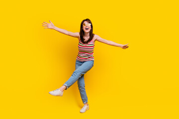 Full size photo of gorgeous woman dressed knitwear top jeans pants in sunglass dancing having fun isolated on yellow color background