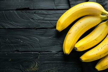 Bananas on a black wooden surface. Tropical Fruits. Top view. Free copy space. - Powered by Adobe